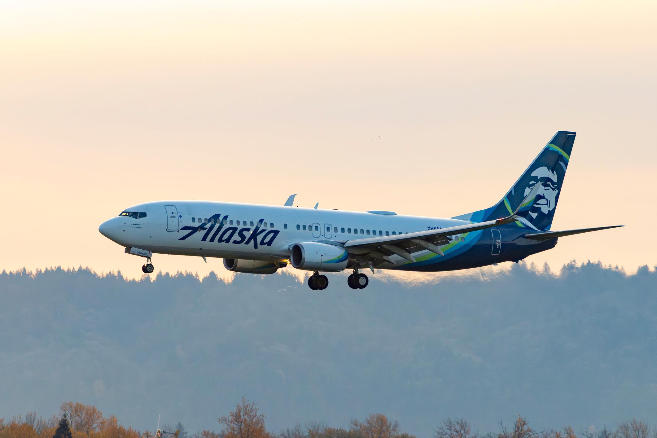 Portland, Oregon, USA - November 30, 2025: An Alaska Airlines Boeing 737 comes in for landing at dusk onto runway 10R at Portland International Airport.