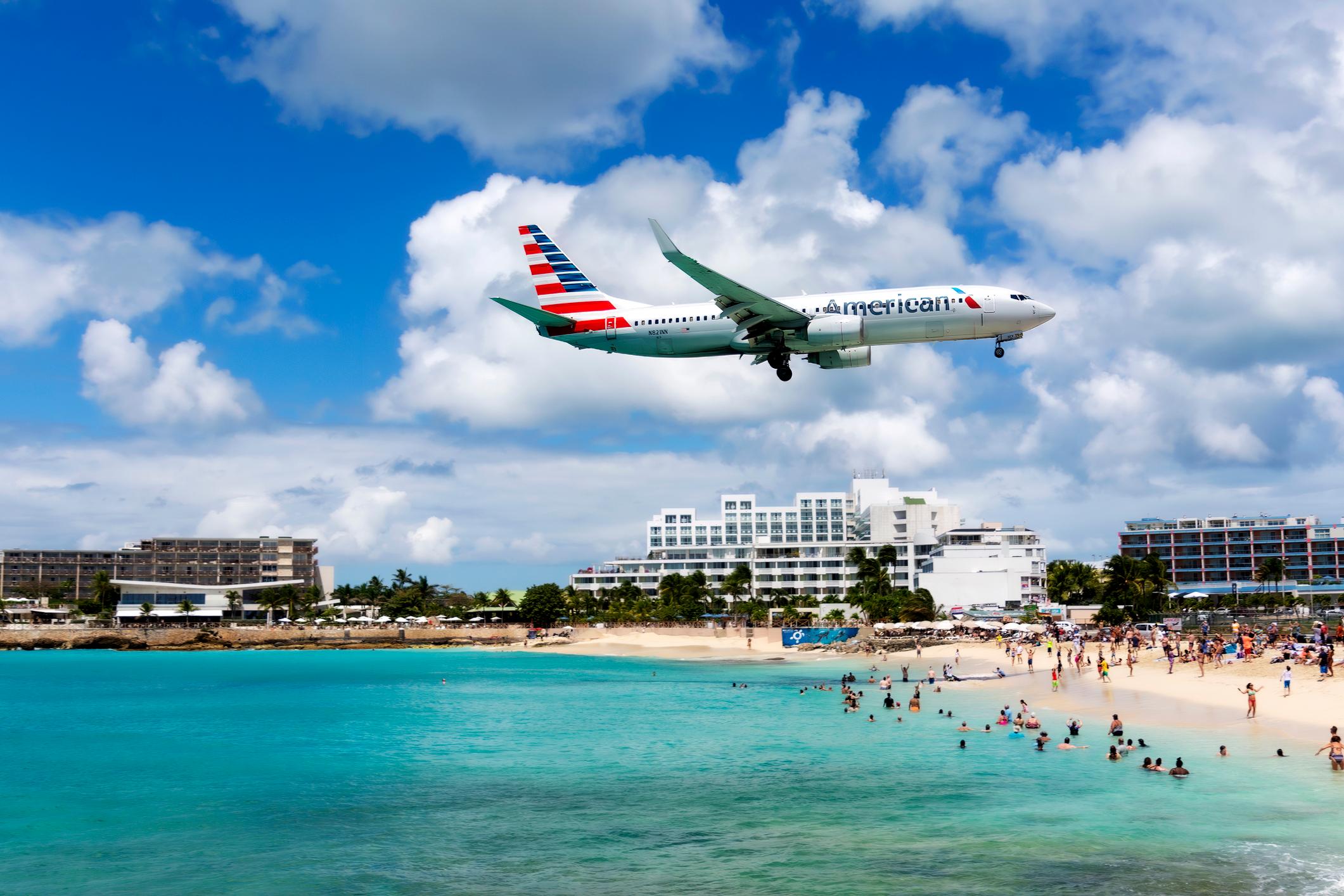 Plane landing at Princess Juliana International Airport while flying over Maho Beach
