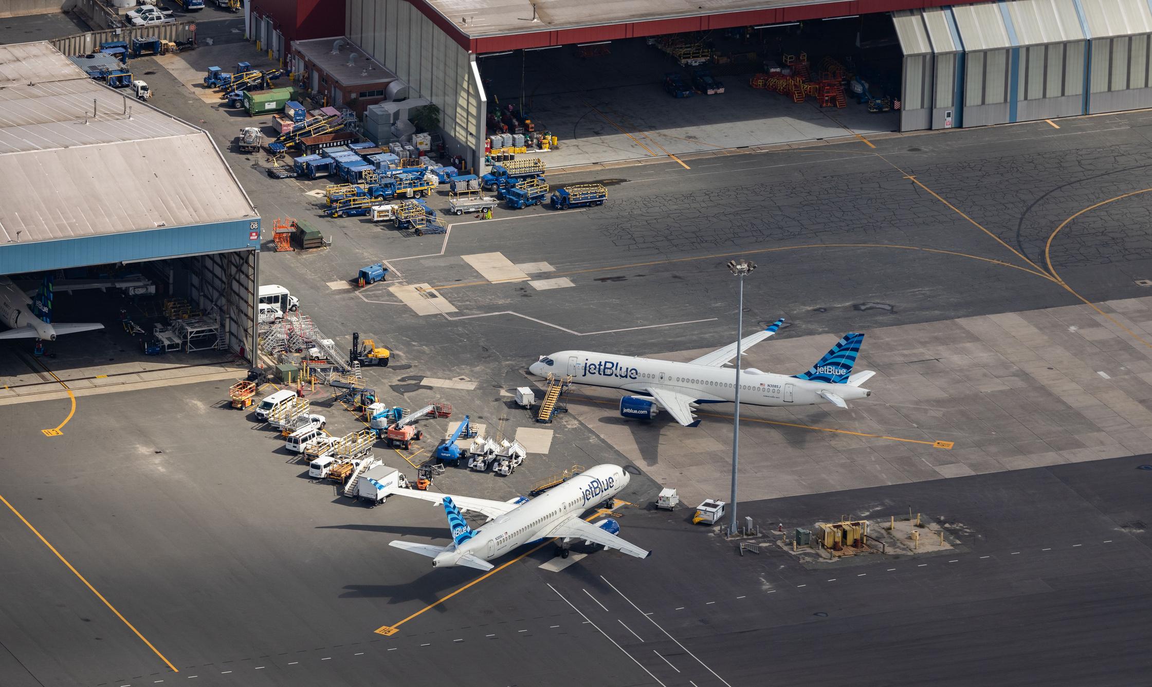 An aerial photograph of a pair of JetBlue Airways planes parked near hangars in Boston